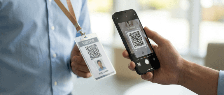 Person scanning a QR code on visitor badge with smartphone for identity verification.