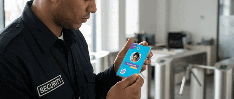 Security officer holding a smartphone displaying an ID verification app.